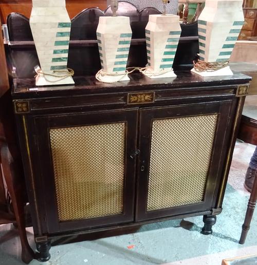 A Regency ebonised and gilt decorated side cabinet with ledge back, frieze drawers and pair of brass grill cupboard doors, 104cm wide.  H6