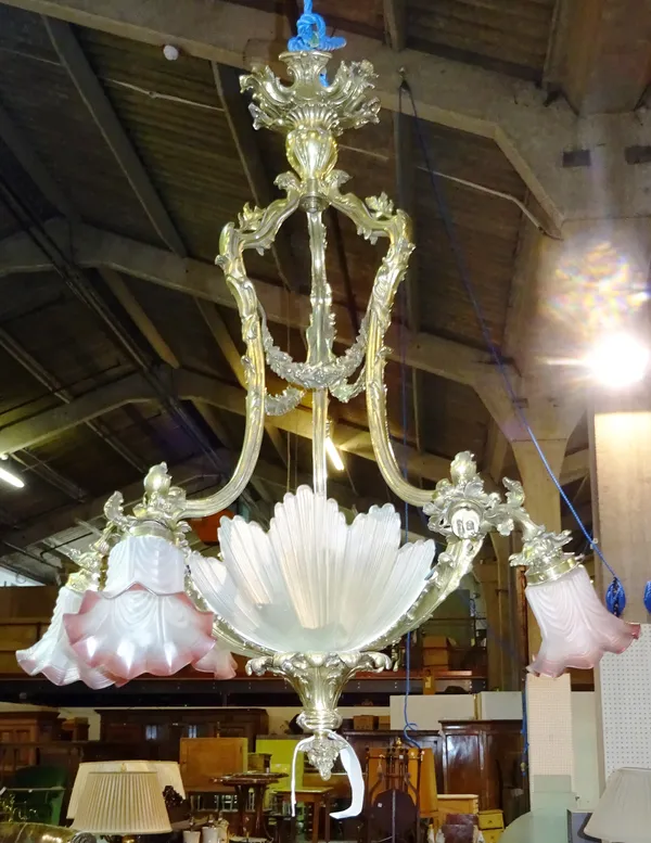 A French gilt bronze six branch chandelier, early 20th century, the foliate cast open frame issuing six branches with frosted and cranberry glass shad