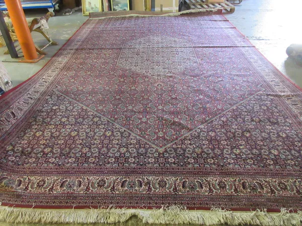A machine made carpet of Persian design.  Please note that this lot is subject to VAT on the hammer