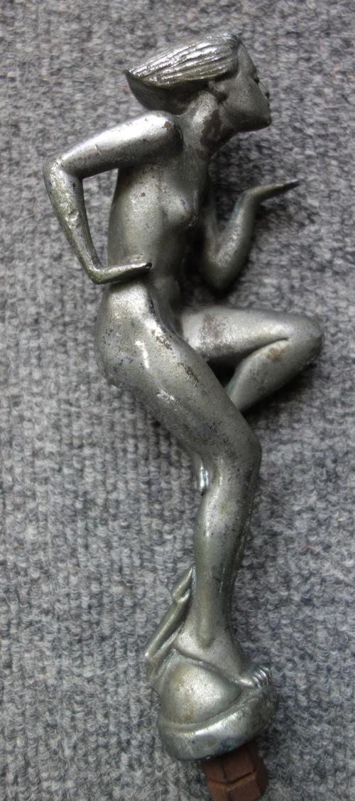 A chromed metal Art Deco car mascot, 'Spirit of Speed', signed to the base 'M. Hiley', 19.5cm high, and a car dash eight day clock, with subsidiary se