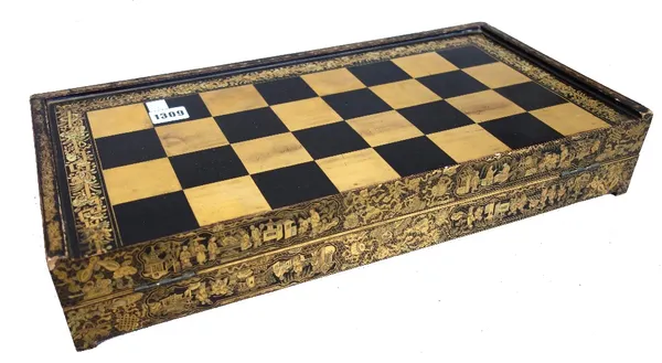 A Chinese export folding chess and backgammon board, circa 1900, gilt chinoiserie decorated against a black lacquered ground, 49cm wide.