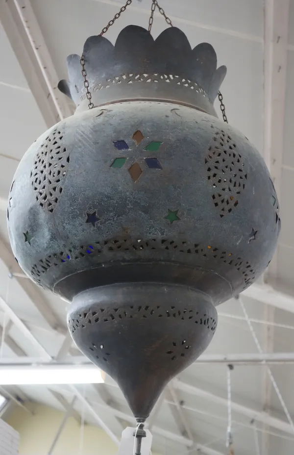 Three Middle Eastern sheet metal and coloured glass hanging lanterns, 20th century each of 'onion' shaped, with pierced foliate designs highlighted wi
