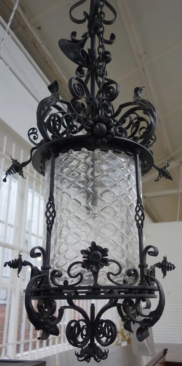 A Victorian style black painted wrought iron lantern, late 20th century, with a long suspension rod over a circular frame and glass shade with all ove