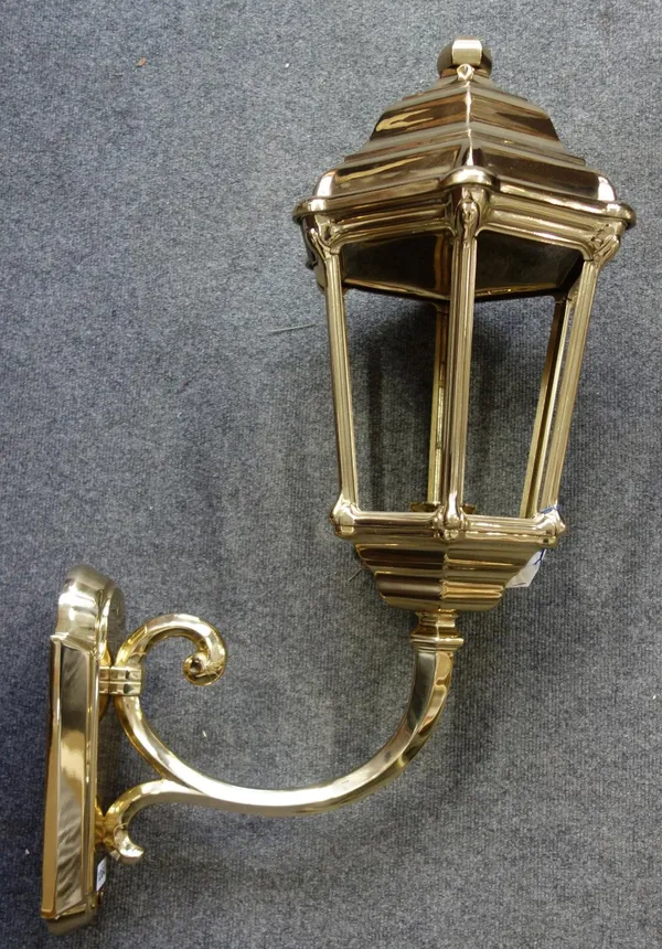 A Victorian style gilt brass wall lantern of large proportions, modern, the hexagonal tapering light supported by a scroll arm and shaped back plate.