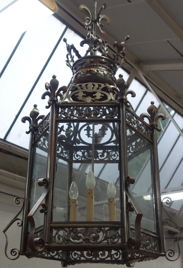 A Victorian style sheet steel hanging lantern, late 20th century, of hexagonal form, with fleur-de-lys crown surmount over a pierced frame and glazed