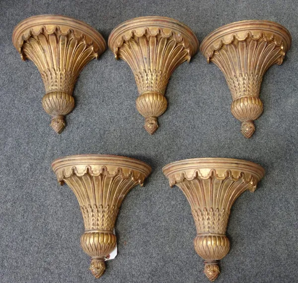 A set of five modern gilt wood up-lighters, each with demi lune castellated rim over a foliate carved tapering body terminating in a pineapple finial.