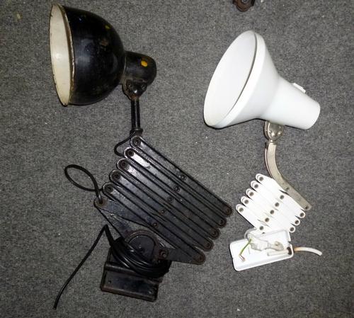 After Christian Dell; a work bench lamp, with circular shade above concertina action frame, unmarked, 44cm high; a similar later white lamp; a Dugdill