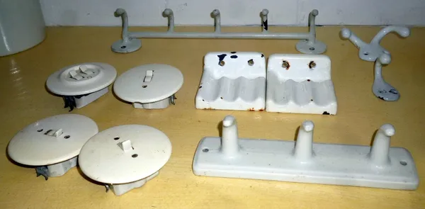 German mid-war and later domestic fittings, to include; a five hook painted coat hook; a three hook porcelain coat hook; two soap holders; four round