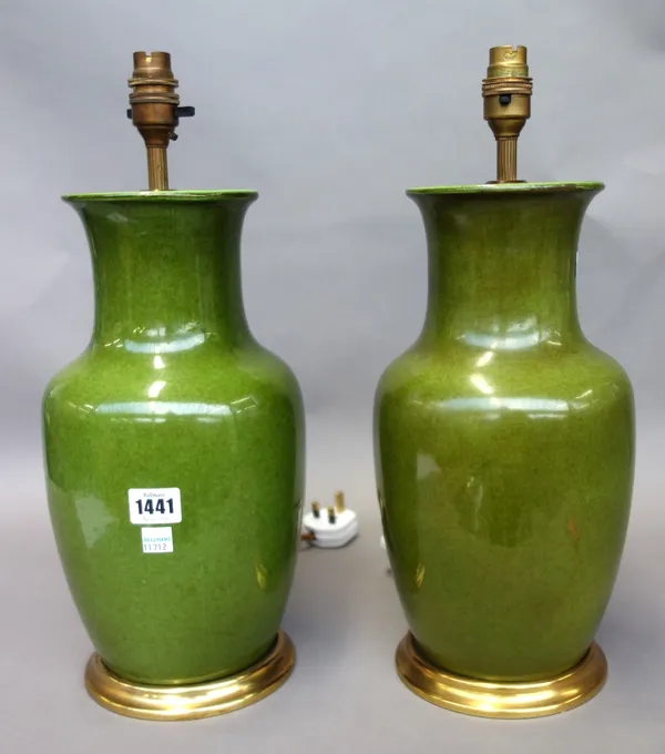 A pair of green glazed pottery table lamps, 20th century, each of vase form on a circular gilt wood base. (34cm high excluding fitments) (2)
