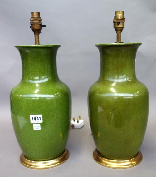 A pair of green glazed pottery table lamps, 20th century, each of vase form on a circular gilt wood base. (34cm high excluding fitments) (2)