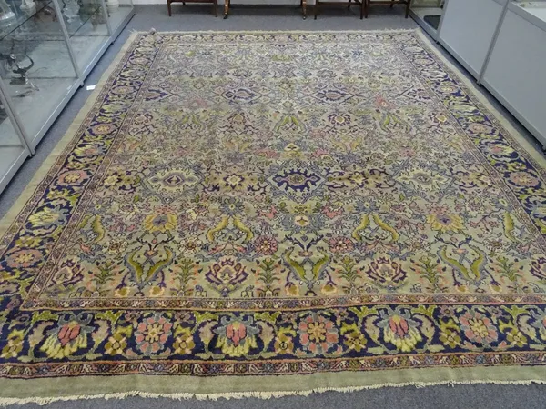 A Mahal carpet, early 20th century, pale green ground with all over design of palmettes and leaves, in a dark blue meandering flower head border, 387c