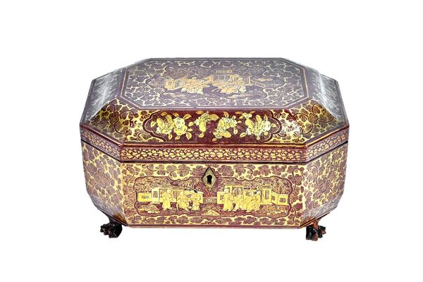 An early 19th century Chinese export red lacquer chinoiserie decorated tea caddy, of compressed octagonal form, with twin lidded interior, 25cm wide x