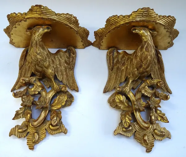 A pair of gilt framed wall brackets cast as a pair of opposing eagles, on foliate bases, 35cm wide x 41cm high, (2).