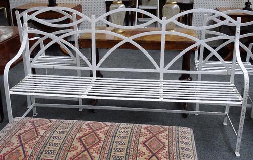 A Regency style white painted wrought iron triple hump back garden bench, 181cm wide x 101cm high, together with two matching armchairs, 56cm wide x 1