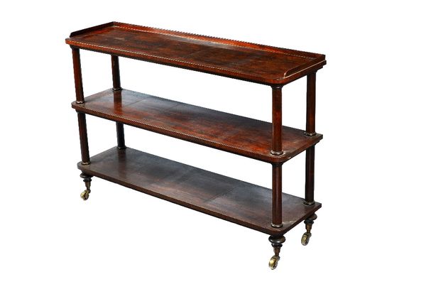 A Regency rosewood three tier serving buffet, with rounded rectangular platform and turned supports, on over size brass castors stamped S. DOBBINS & C