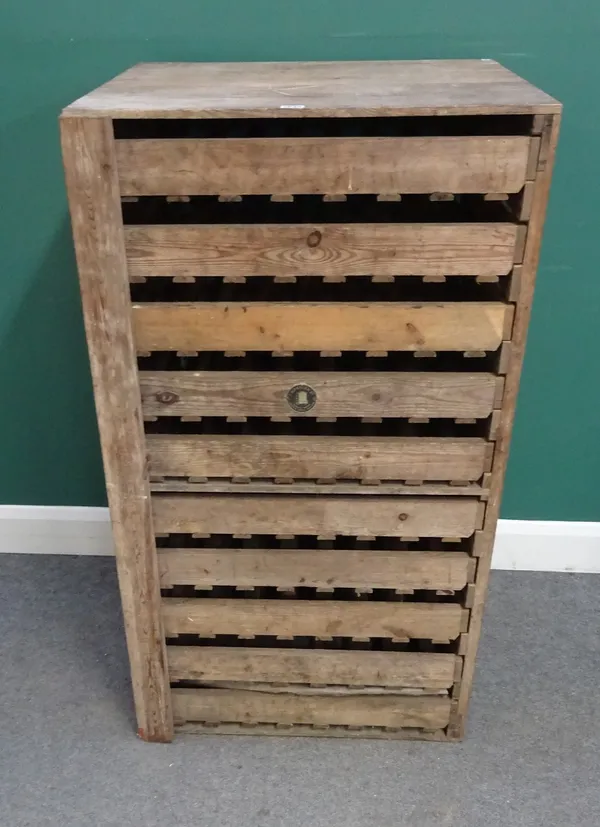 EM Taylor Ltd, Beehive works, Welwyn, Herts, England; a 20th century pine apple storage rack, with ten trays enclosed by locking bar, 67cm wide x 120c