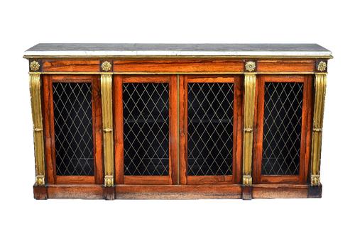 A William IV side cabinet In the manner of Marsh & Tatham, the marble top over four grille doors, divided by gilt scrolls, on a plinth base, 187cm wid