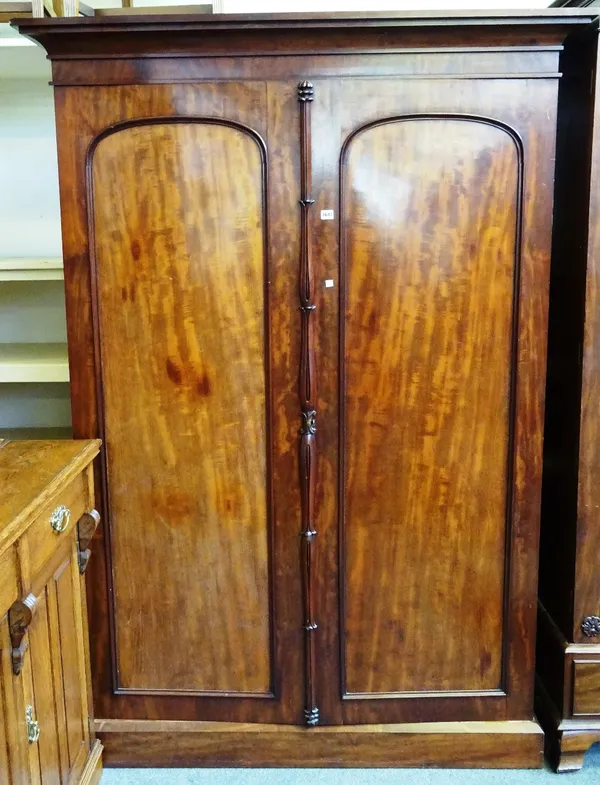 An early Victorian mahogany two door wardrobe, with fitted interior, on a plinth base, 127cm wide x 204cm high x 57cm deep.