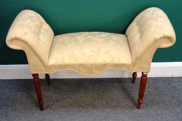 A Regency style window seat, with outswept arms and shaped seat, on reeded supports, 100cm wide x 67cm high x 40cm deep.