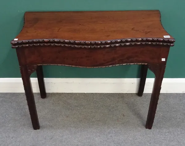 A mid 18th century mahogany card table, with serpentine top on carved canted square supports, 90cm wide x 44cm deep x 73cm high.
