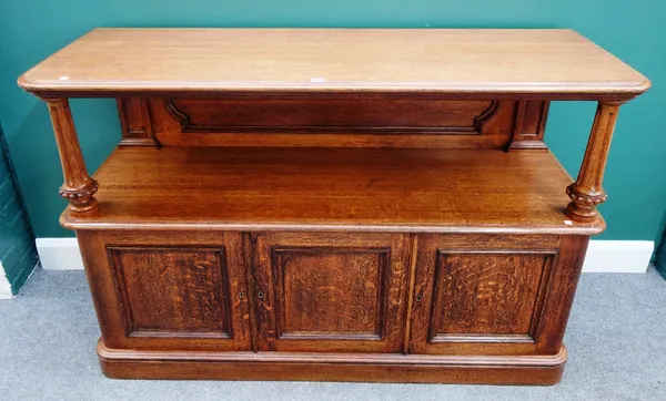 A Victorian oak buffet, the pair of open tiers united by panel back, over three cupboards enclosing linen trays, 154cm wide x 100cm high x 54cm deep.