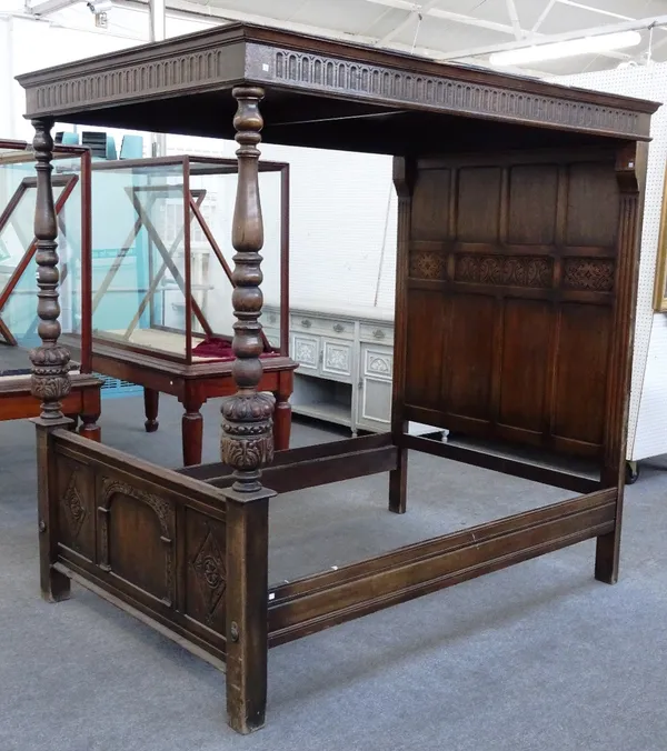 A mid 20th century carved oak four poster bed, of 17th century design with panelled canopy and headboard, the footboard on turned supports, 148cm wide