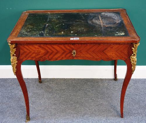 An 18th century French gilt metal mounted mahogany writing table with leather inset top over single frieze drawer on cabriole supports, 81cm wide x 72