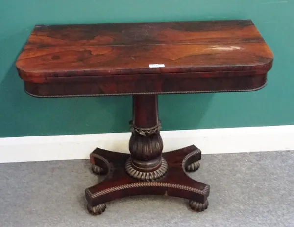 A William IV rosewood card table, the 'D' shaped top on turned and carved column and melon carved feet, 92cm wide x 74cm high x 46cm deep.