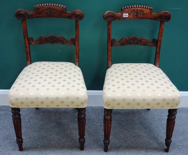 A pair of early 19th century faux rosewood side chairs, with carved crest and waist rail, on reeded supports, 47cm wide x 85cm high x 45cm deep, (2).