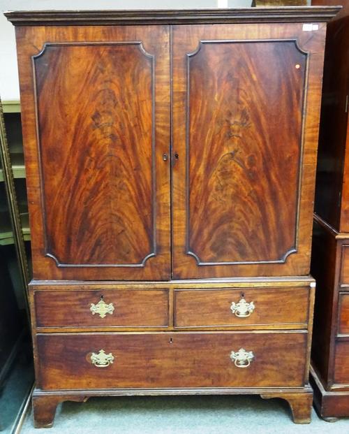 A mid 18th century mahogany linen press, the pair of panel doors over two short and one long drawer, on bracket feet, 123cm wide x 176cm high x 56cm d