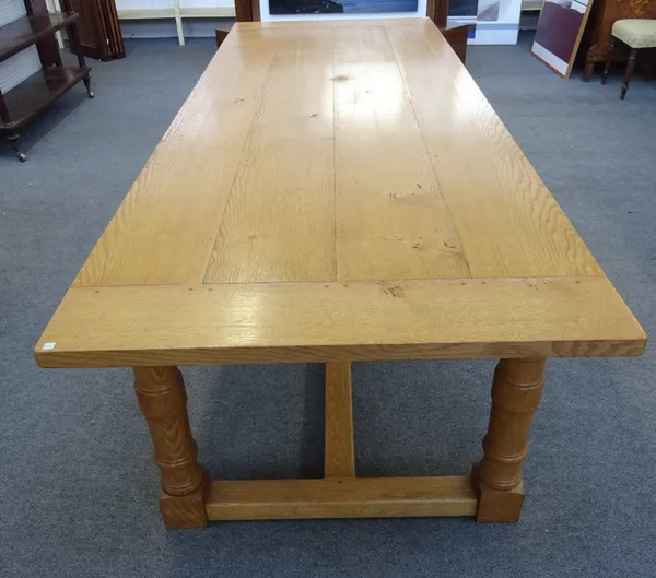 A 17th century style oak refectory table, the cleated plank top on four turned supports, united by 'H' frame stretcher, 290cm long x 77cm high x 105cm