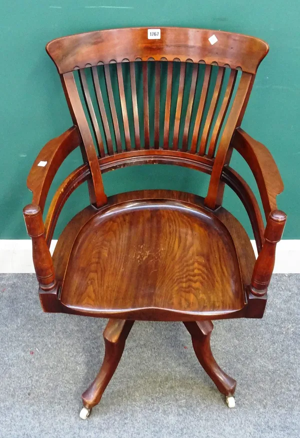After E.W. Godwin, a late 19th century walnut office swivel chair, on four downswept supports, 57cm wide x 88cm high.