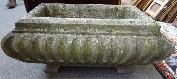 A rectangular carved stone trough, of fluted sarcophagus form, on block feet, 79cm wide x 37cm high x 50cm deep.