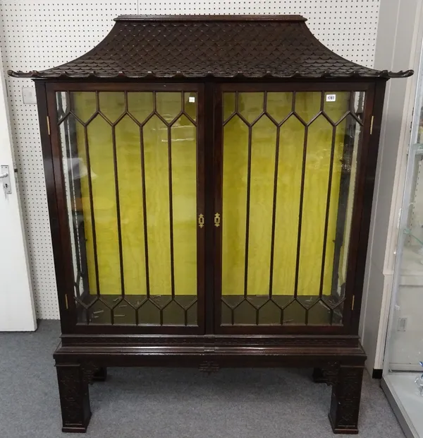 A Chinese Chippendale Revival mahogany display cabinet, the carved faux tiled roof over pair of astragal glazed doors on four blind fret carved suppor