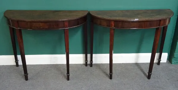 A pair of George III mahogany console tables, each with 'D' shape top on four tapering square supports, 98cm wide x 78cm high x 40cm deep.