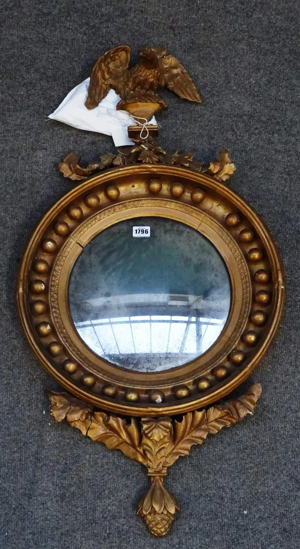 A 19th century Regency style gilt framed convex wall mirror with eagle surmount, 46cm wide x 90cm high.