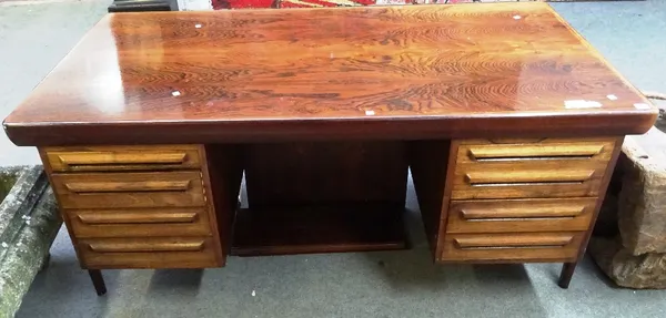 A mid 20th century rosewood writing desk, the rounded rectangular top over a pair of four drawer pedestals, 160cm, wide x 85cm deep x 72cm high.