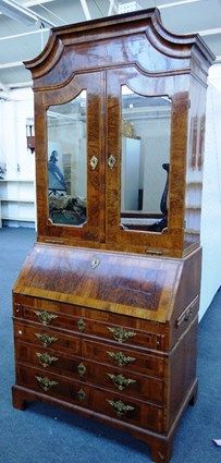 An 18th century German figured walnut bureau cabinet, the pair of mirrored doors over a fitted interior, one long, two short and two further long draw