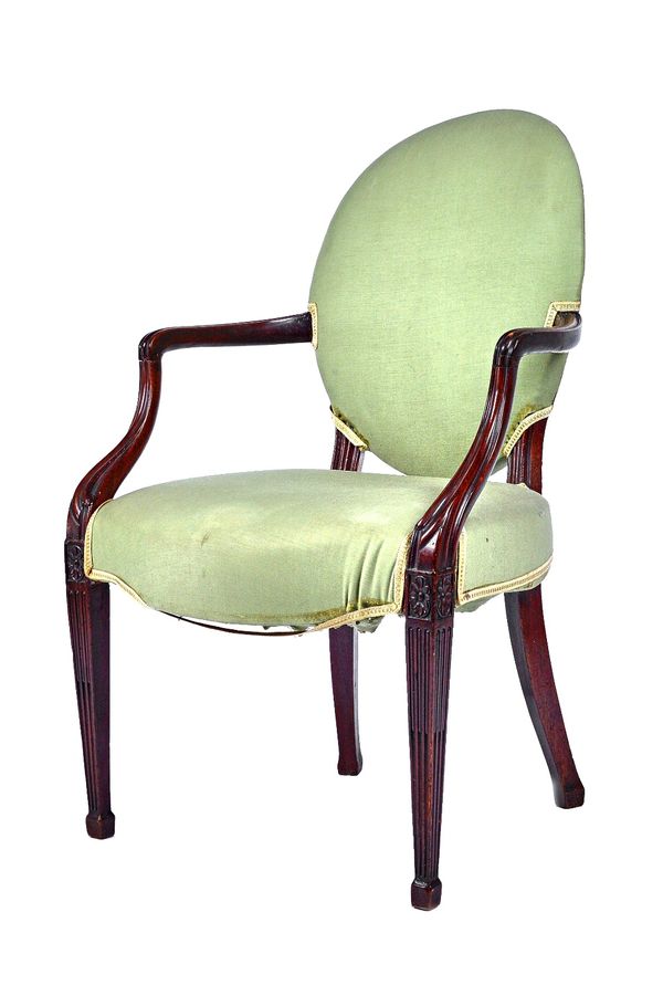 A George III mahogany pierced oval back open armchair, with serpentine seat on rosette capped fluted tapering square supports, 61cm wide x 94cm high.