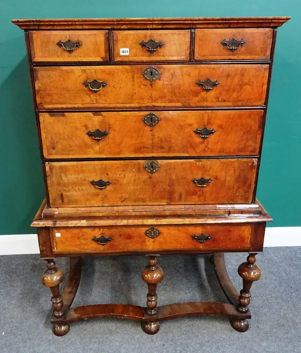 An early 18th century walnut chest of three short and three long graduated drawers, the lower later secretaire fitted on a single drawer base and bulb