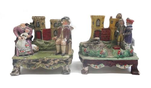 An unusual Staffordshire pearl ware spill vase figure group, early 19th century, depicting a family group atop a footed base, 20cm wide, and one furth