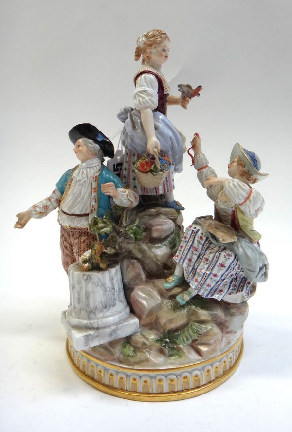 A Meissen porcelain figure group, 19th century, depicting three garden children after the original by Michel Victor Acier, blue crossed swords mark, i