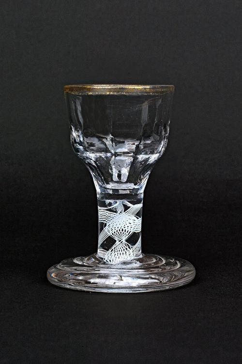 An opaque twist firing glass, circa 1760, the hammered ogee bowl raised on a double series opaque twist stem and terraced foot, traces of gilding to t