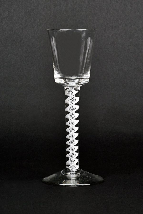 An opaque twist wine glass, circa 1760, the bucket bowl raised on a double series opaque twist stem and plain foot, 15.5cm. high.  Illustrated