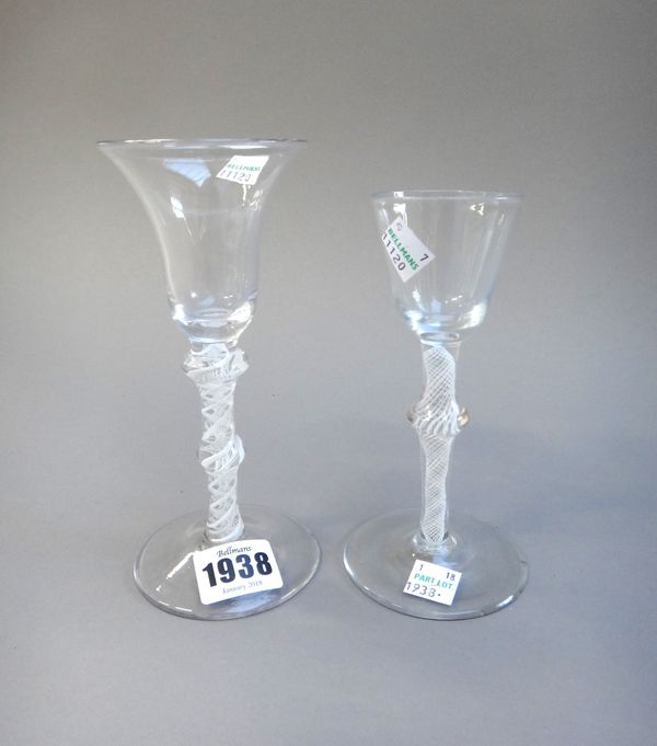 Two opaque twist wine glasses, circa 1760, the first with trumpet bowl and double knopped stem, the second with rounded funnel owl and knopped stem, (