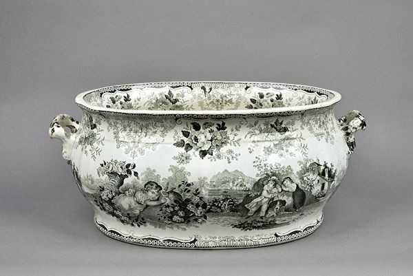 A large twin handled Victorian foot bath, with black printed decoration depicting children and animals, (a.f) with an Oriental church landscape to the