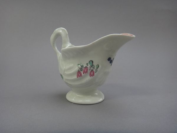 A small Christian's Liverpool 'dolphin ewer' creamboat, circa 1770, painted with scattered flowers, the interior with an iron-red loop and dot border,