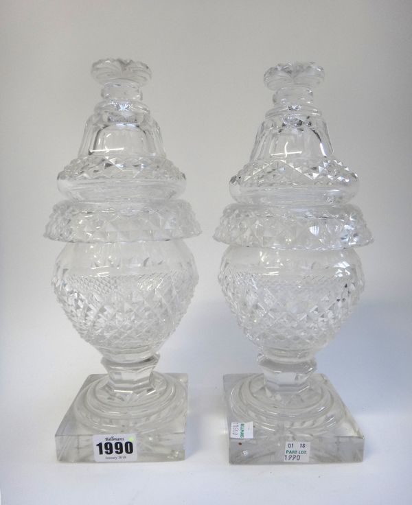 A pair of early 19th century Irish glass sweetmeat urns and covers, each on a square foot with star cut base (29cm high), a part suite of William IV s