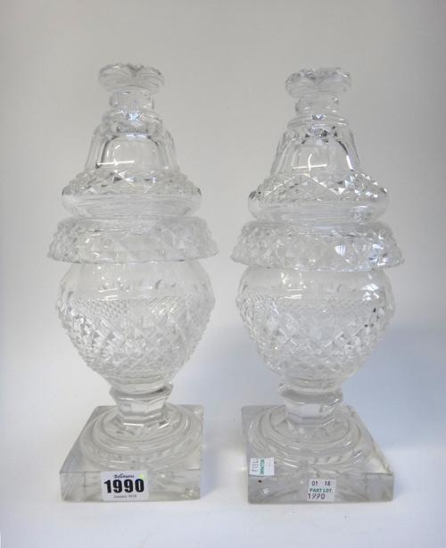 A pair of early 19th century Irish glass sweetmeat urns and covers, each on a square foot with star cut base (29cm high), a part suite of William IV s