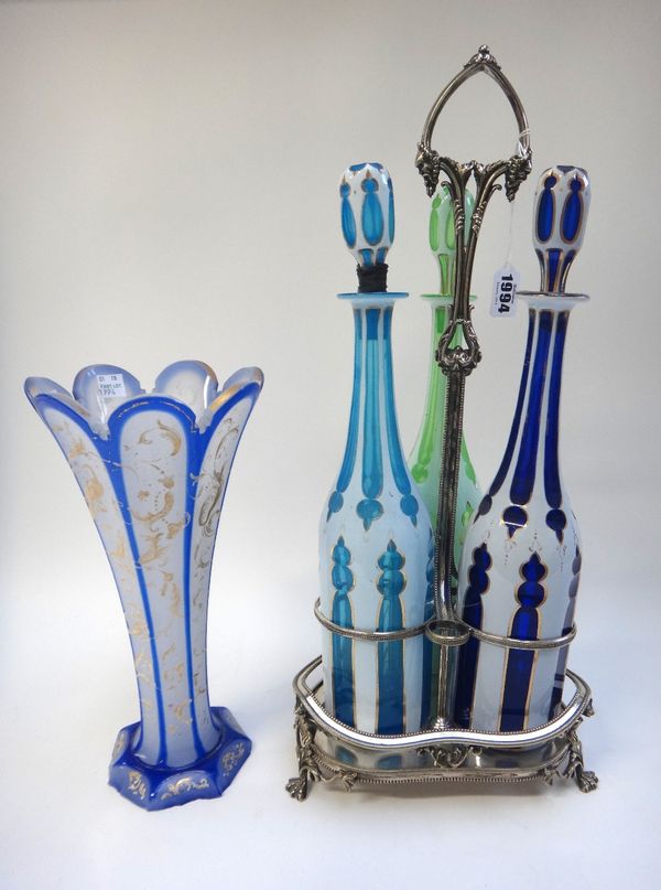 A set of three Bohemian gilt coloured and cut glass decanters and stoppers, 19th century, in a silver plated stand (47cm high) and a Bohemian flared b